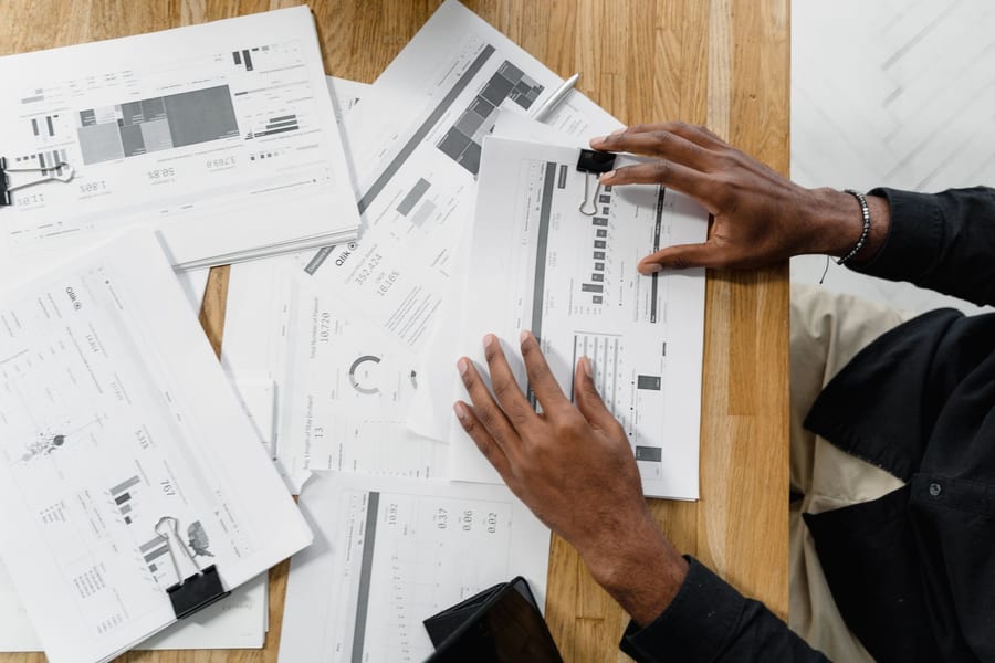 Financial documents spread out and being reviewed on a desk